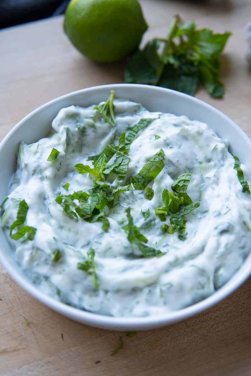 vegan tzatziki sauce in bowl with mint on top