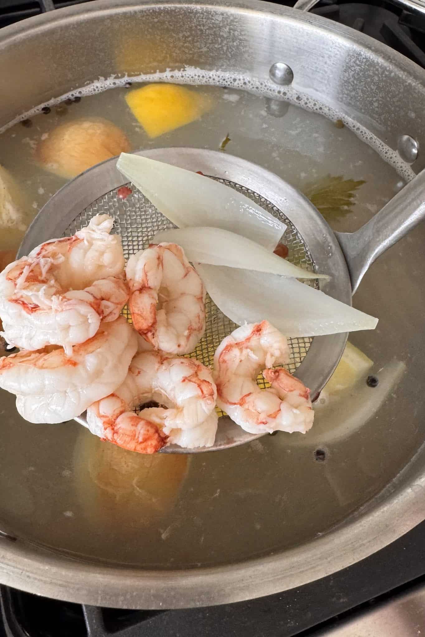 pot with boiling water and slotted spoon removing shrimp