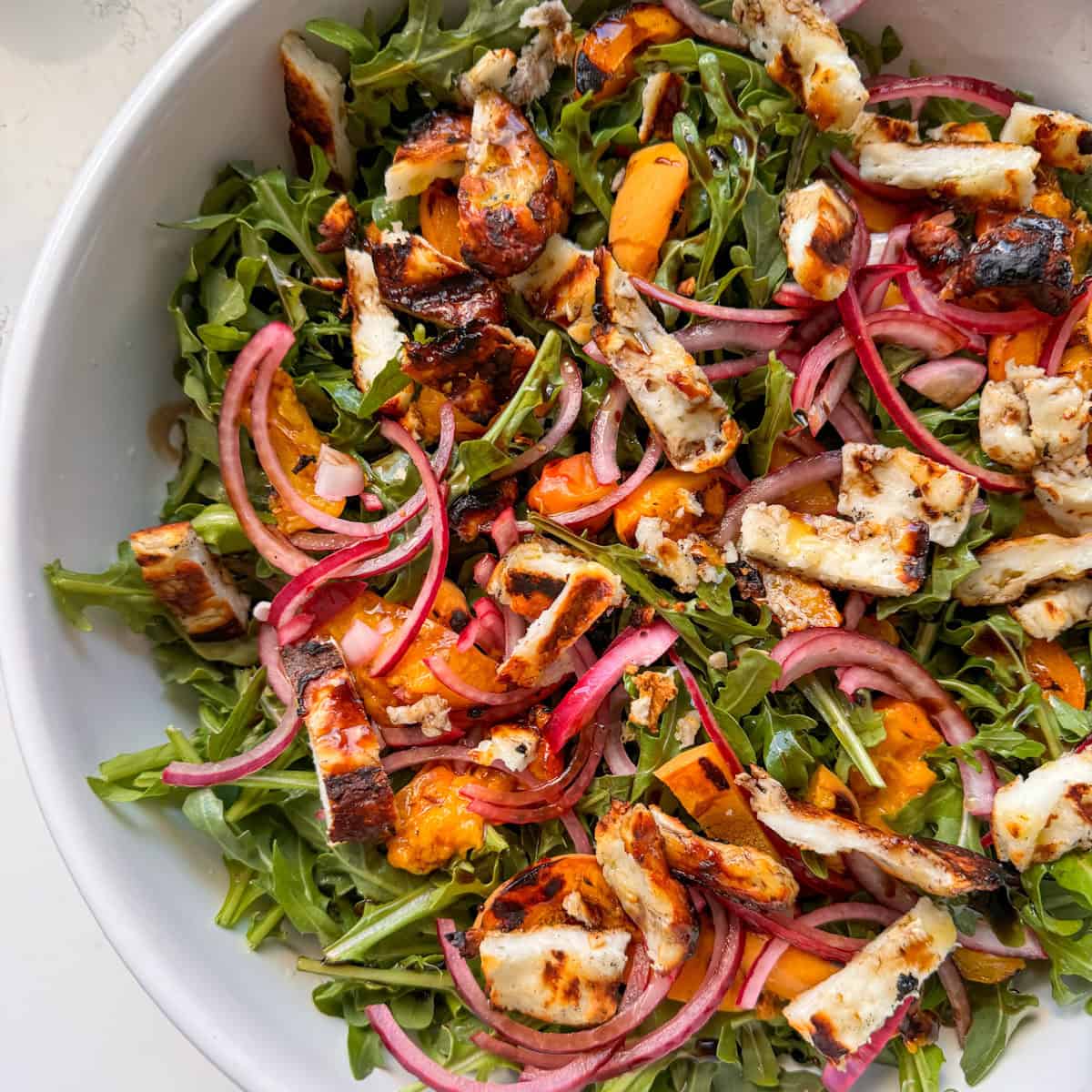 arugula salad with grilled apricots, halloumi and red onion