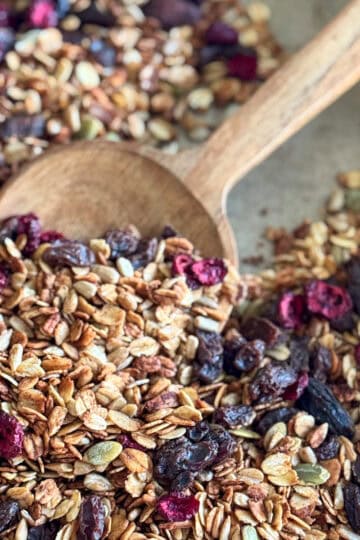 baking sheet with granola and wooden spoon